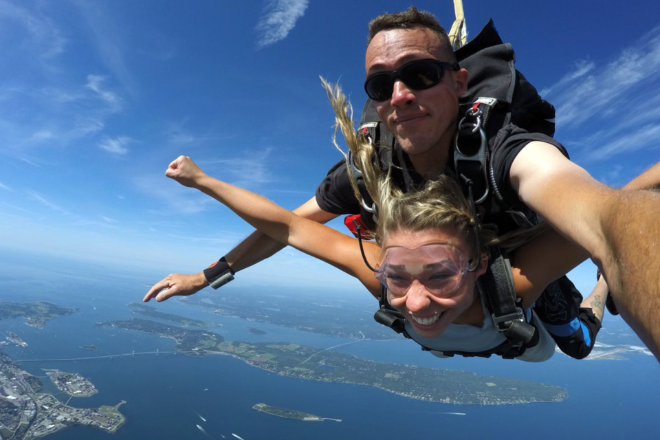 girl tandem skydiving over New York